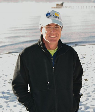 David MacLeod standing on beach smiling.