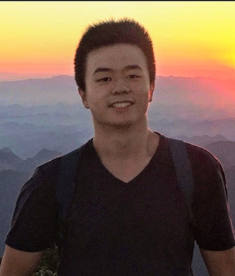 Jiawei in front of a mountain during sunset.