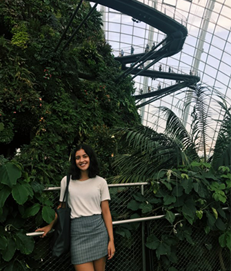 Kathleen standing inside botanical gardens. 