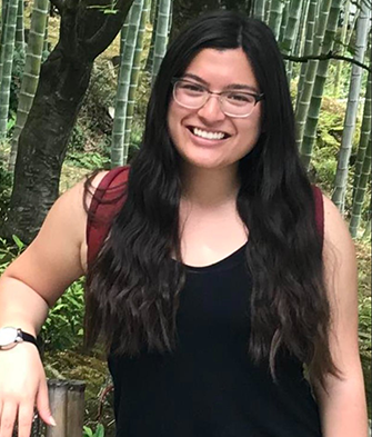 Kim smiling in front a bamboo forest.