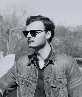 Black and white photo of Logan in sunglasses.
